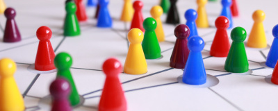 Netzwerk: Mehrere bunte Spielfiguren stehen auf einer weißen Fläche mit Verbindungslinien.